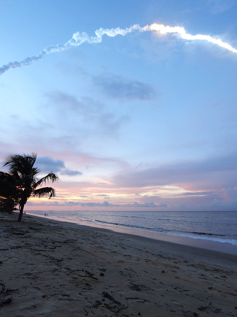 Traînée d'un lancement dans le ciel au-dessus de la plage