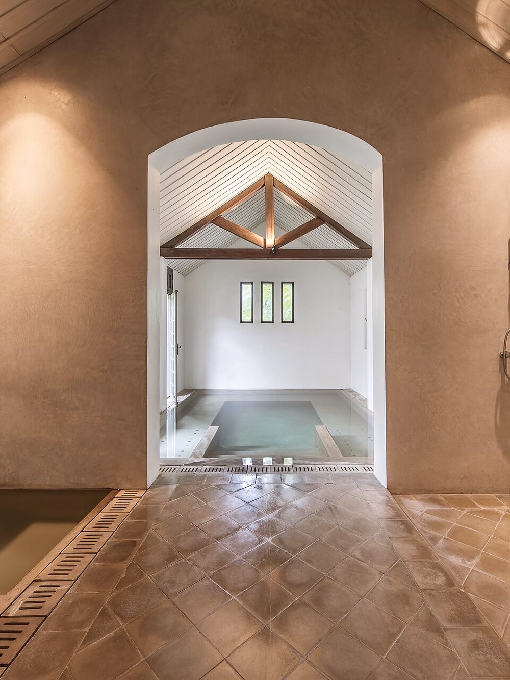 Bassin intérieur du spa sous charpente de bois