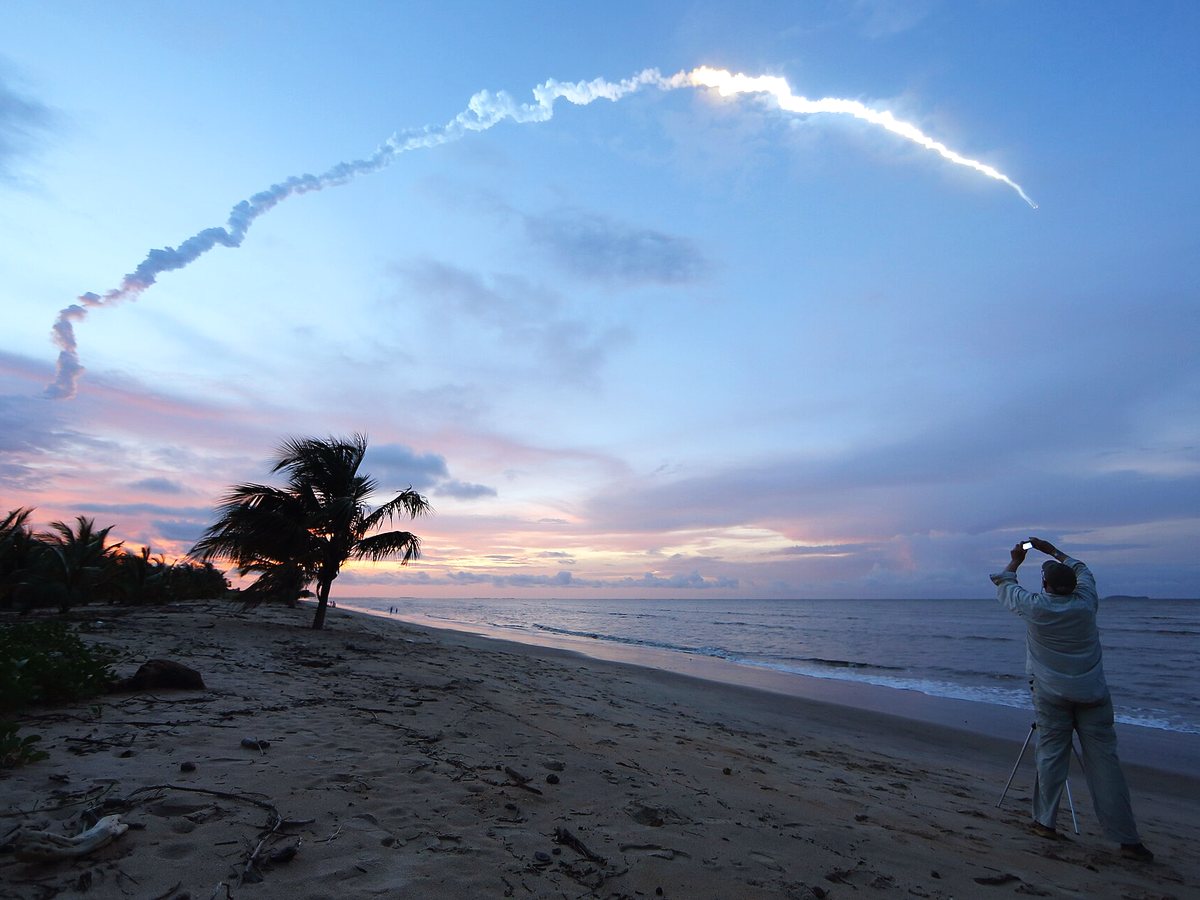Traînée d'un lancement dans le ciel du soir, vue de la plage