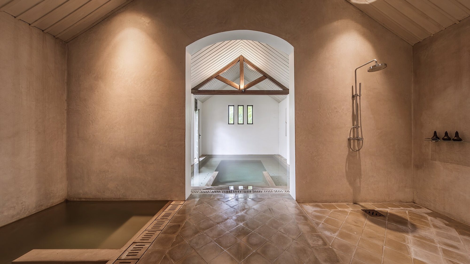 Le bassin intérieur du spa sous une charpente de bois clair